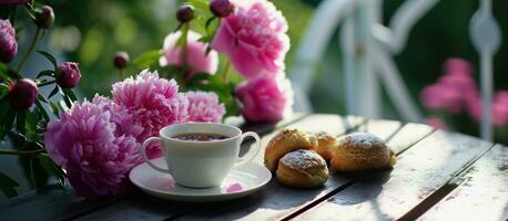 ai generado rosado peonias, taza de té y bollos en el fuera de mesa foto