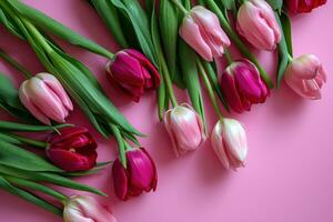 AI generated tulips in shades of pink arrangement in pink background top view photo