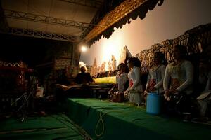 A man perform with wayang or traditional javanese puppet on stage at night. Tuban, Indonesia - 22 September, 2023. photo