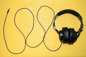 top view headphone with cable on yellow background photo
