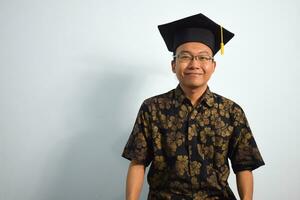 Expressive of Adult indonesia male wear batik, toga cup or graduation hat and eyeglasses isolated on white background, expressions of portrait graduation photo