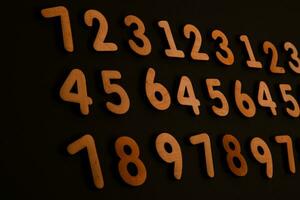 Wooden numbers on a black background. Numbers of different colors. photo