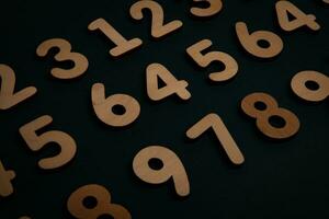 Wooden numbers on a black background. Numbers of different colors. photo