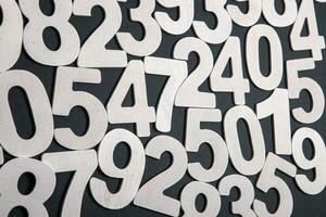 Wooden numbers on a black background. Numbers of different colors. photo