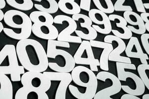 Wooden numbers on a black background. Numbers of different colors. photo