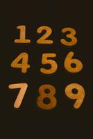 Wooden numbers on a black background. Numbers from zero to nine. photo