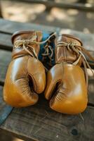 AI generated Two vintage boxing gloves resting on a weathered wooden bench, evoking a sense of nostalgia and the sport's rich history. Generative AI photo