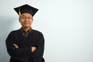 expresivo de adulto Indonesia masculino vestir graduación túnica, sombrero y los anteojos aislado en blanco fondo, expresiones de retrato graduación foto