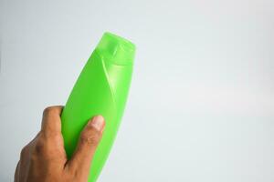 Green blank bottle shampoo minimalist bakcground, hair care bottle mock up product. photo