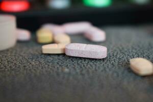 medical pill and bottle with mug or glas of water on table workspace photo