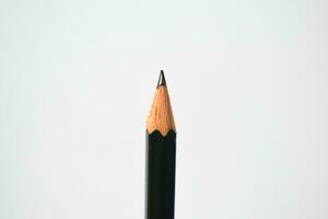 green pencil sharpener and dark green pencils, pencil shavings on white background photo