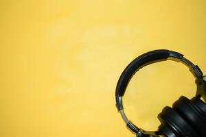 top view headphone with cable on yellow background with copy space photo