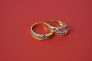 Close Up Golden ring with diamond on isolated red background photo