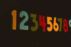 Colorful wooden numbers on black background. Number 1 to 9. photo