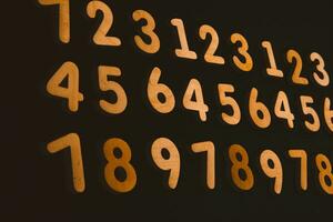 Colorful wooden numbers on a blackboard background with space for text photo