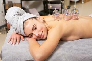 Young woman getting a back massage in a spa salon. Beauty treatment concept. photo