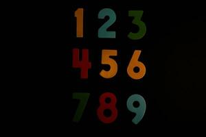 Colorful wooden numbers on black background. Number 1 to 9. photo