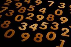 Wooden numbers on a black background. Numbers of different colors. photo