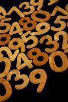 Wooden numbers on a black background. Numbers of different colors. photo
