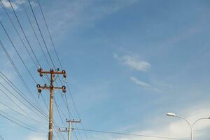 Electric cable poles against a bright blue sky photo