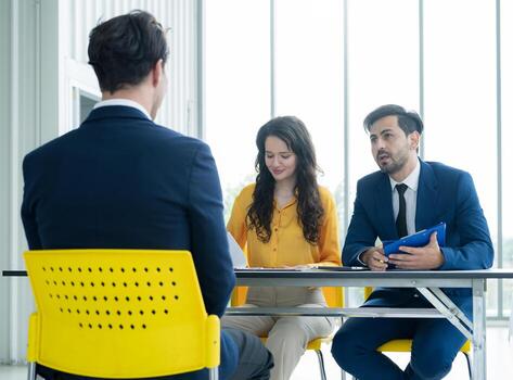 Job interview concept. Diverse hr team doing job interview with a man in business office. Human resources team interviewing a potential job candidate. Hiring, employment, and recruitment concept. photo