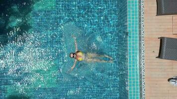 kaukasisch Frau Schwimmen auf das zurück im das Schwimmbad im schleppend Bewegung. video