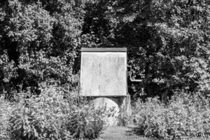 Old well with iron bucket on long forged chain for clean drinking water photo