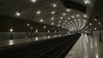 Underground subway tunnel with bright lighting. Action. Simple stone interior of underground metro with bright lighting on tracks photo