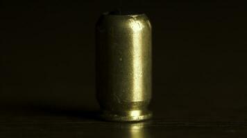 Bullet from the gun placed on a wooden table on black background, macro. One bullet on the table to protect or murder people photo