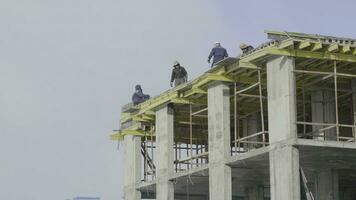 edificio construcción sitio trabajo en contra azul cielo. trabajadores a el construcción sitio de un Departamento edificio foto