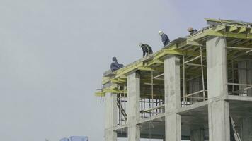 edificio construcción sitio trabajo en contra azul cielo. trabajadores a el construcción sitio de un Departamento edificio foto