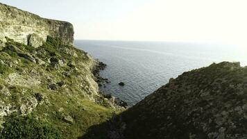 Spectacular view of steep dliffs at the ocean, Ireland. Shot. Green slope near calm water and the endless horizon on clear blue sky background. photo