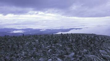 Top view of the mountains with Pyramid of rocks on top. Clip. Stone tower in the top of a mountain photo