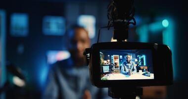 Close up shot of professional camera used by influencer to film live broadcast for online streaming platforms. Recording equipment used by internet star in blurry background hosting q a session photo