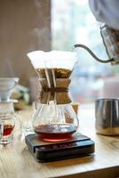 Coffee is brewed in a glass container through a paper filter, an alternative method. photo