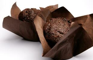 Two chocolate muffins on a white background . Muffin with chocolate chips. photo