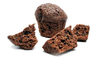 Whole and broken into pieces chocolate muffin isolated on a white background. Chocolate chip muffin. photo