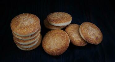 Beautiful round cookies on a black background. A few cookies. A bunch of cookies. photo
