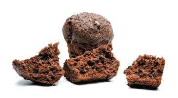 Whole and broken into pieces chocolate muffin isolated on a white background. Chocolate chip muffin. photo