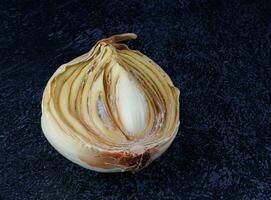 Half of a rotten onion on a dark background. Rotten and moldy onions. photo