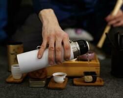 Boiling water pouring from a thermos into a mug. Tea ceremony photo