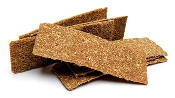 Slices of healthy low calories grain crisp bread for snack and crumbs on white background. photo