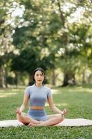 Portrait of young woman practicing yoga in garden.female happiness.  in the park blurred background. photo