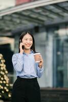 Young Asian business woman leader entrepreneur, professional manager holding digital tablet computer uon the street in big city photo