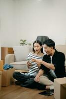 Happy asian young attractive couple man and woman with big boxes moving into a new house, new apartment for couple the new home, Moving house. photo