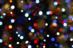 Colorful bokeh lights - big, small, blue, red. Abstract blurred Christmas tree garland lights background. Holiday New Year illumination and decoration concept. Defocused image. photo