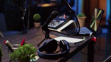 Close up shot of specialized radio microphone used in home personal studio by dj to record internet show guests. Professional audio devices in empty living room used for producing internet show video