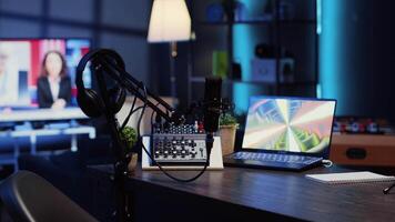 Panning shot of podcast microphone used to record discussions for internet livestreaming channel and 3D renders running on notebook screen. High tech streaming sound capturing and recording devices video