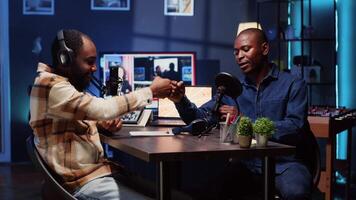 Podcast presenter having live discussion with man, using headphones to review music together. Influencer enjoying chat with guest, streaming it for audience on internet show video