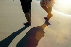 close up rear view of a couple walking on the shoreline photo